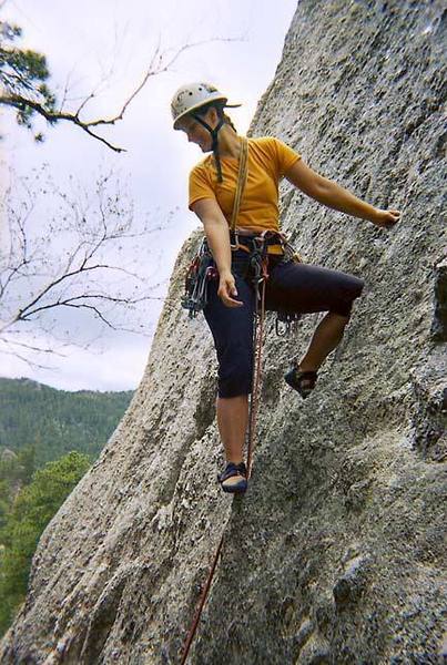 Angela looks down to make sure she's on belay before placing some gear on Enting.