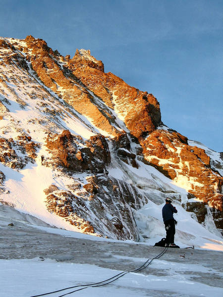 Crossing the Eliot Glacier.  The north face route goes up either of the two couloirs above the climbers head.