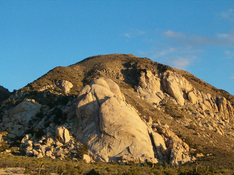 Saddle Rocks from the road near Hall of Horrors. The Theoretical Boulder is visible to the left and the Cowboy Crags up and to the right.