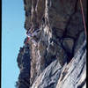 1981. The Fat City Direct crux en route to the first continuous ascent of Requiem via the Fat City Direct variation. Fat City Direct climbs straight up to where I am in the photo. Requiem climbs a wild feet dangling hand crack over a bright orange roof just out of the photo to the right. The true Requiem crux, originally aided, first went free at 12 something, and then a hold broke (but maybe still free). The large right facing corner at the left of the photo is Gelsa, 5.4.