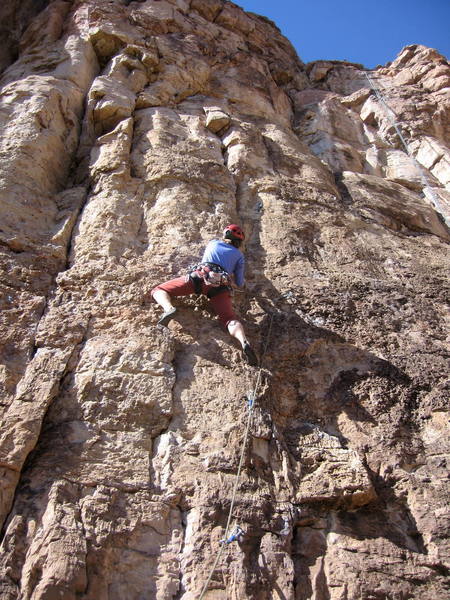 Christa Cline getting ready to crank the hard move into the crack at the third bolt.  <em>Don't Be Messin' With Ma Moves</em> traverses right at this point; <em>Six More Bottles of Basco</em> continues straight up the crack.<br>
<br>
The flared chimney with two roofs on the left of the photo is <em>Fully Equipped</em>.  The line just to Christa's left is <em>Early Bird</em>.  The rope on the right of the photo is on <em>Chompin' at the Cholla</em>.