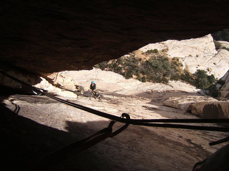 Looking down at the first belay of Arch Enemy from within the chimney/tunnel on pitch 2.