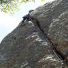 Approaching the final moves, a long clip to the bolt up and right is quite hard.  As the bolt hanger is about 1" from the rock, lassoing the bolt itself is a good idea.  A hard, thin, long reach is then required to reach a final jug.  Two new bolts are found just left around the corner on the face.