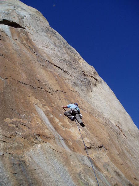 Paul just passed the first bolt on thin ground.  The route continues up to thin diagonal crack a few feet above his head and moves right and up (1st crux) to second bolt.