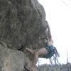 Setting up for the longer reach above the roof. This is the technical crux. Image by Brian Freund