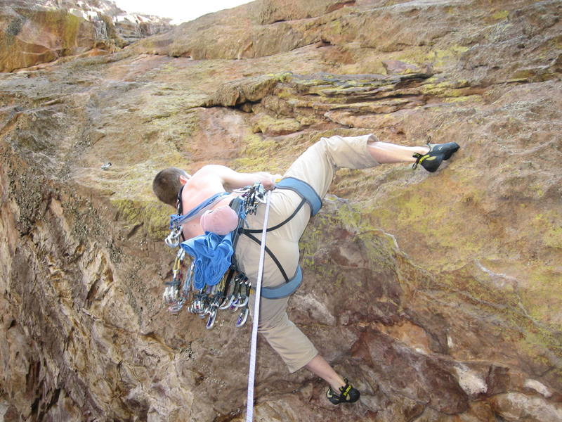 Joseph Crotty sets up for the now missing (i.e., as of 2013-02-17) inverted knife blade clip just off the deck at the lip of P1 pitch of Jules Verne. A new knife blade was placed with a park permit in a like for like replacement. The new pin would be seen just above the climber's right ankle.