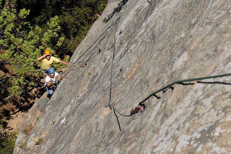 Another way of doing things: lately, when I am taking inexperienced climbers up Face Lift, I climb the pictured variation.  This variation involves pulling up early on the first pitch and belaying from a comfortable ledge.  The second pitch bypasses the usual belay stance altogether and climbs straight up from the route's fourth bolt and passes another bolt to gain an obvious ledge with trees.  While this is seriously runout for the leader, it is much less likely to produce a serious pendulum for the second.  I believe that this variation follows the upper portion of the route known as "Tigger Treat" (5.8) in the Edward's Guidebook.