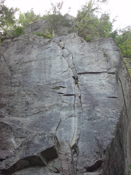 The thin cracks of Even Steven from the ground. The cruxes come at the thin section low on the route (just above the huge ledge) and up higher beyond the slightly broken section.