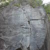 The thin cracks of Even Steven from the ground. The cruxes come at the thin section low on the route (just above the huge ledge) and up higher beyond the slightly broken section.