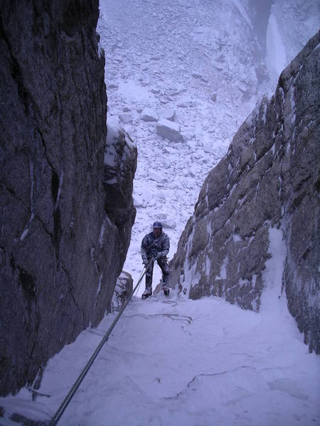 Rappeling the second pitch of the left chimney variation during heavy spindrift.