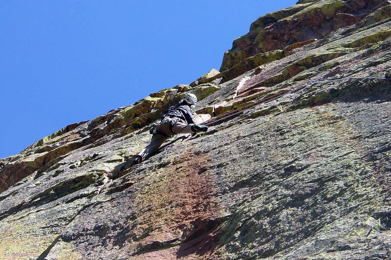 Looking up at the first hard moves in the left crack. The first move to get stood up into the shallow, right-facing corner is easy with a trick, but then it's problematic just staying there due to no handholds.<br>
<br>
Photo by Paul Rezucha.