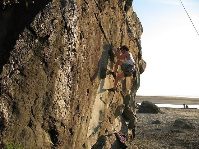 Marc setting up to grab the namesake feature on Lizard Head (5.10d), Moonstone Beach 