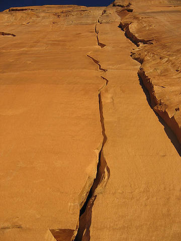 Pitch 1 of Brits in the Belfry: Sandy splitter hands forever to a pod/roof below a steep finger crack (5.11++).