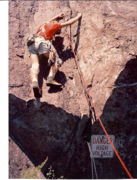 Leading first pitch of "Danger High Voltage" way back in the very early 80's.  Don't know why I climbed the route this way- oh ya... to get the sign in the picture.  It was a blue sky day all day.