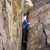 Bouldering up the short chimney to get to the start of "Rosie."