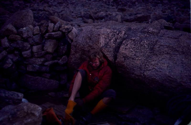 Photo:Olaf Mitchell.<br>
Buc Taylor at the boulder field bivy before dropping in on The Diamond in the late '70s.<br>
"We're mountaineers.<br>
We're mountaineers.<br>
We sleep in holes and ditches.<br>
We wipe our arse with broken glass.<br>
And laugh because it itches.<br>
We're mountaineers.<br>
We'er mountaineers.<br>
We're low down Sons Of Bitches!"