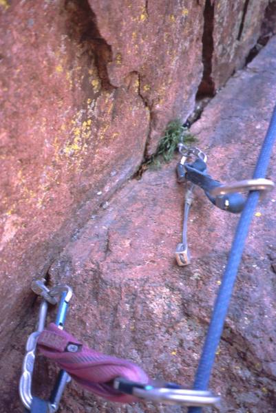 This is a photo Joseffa stopped to take of the gear in question on 'Rincon' the last time we did the route. Note the "bad" pin that is at chest level, and the bomber stopper placed above it. For reference, that blue sling is 1-foot long. The flake just left of the placement is a jug. You can both see and place the stopper when the pin is at your arm-pit.