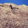 Tony Bubb higher up on the endless slabs of the East Face Left on the 3rd Flatiron. The bottom section added to this route over the standard East Face makes it a longer and better and better route.<br>
<br>
Photo by John Saccardi, 2002.