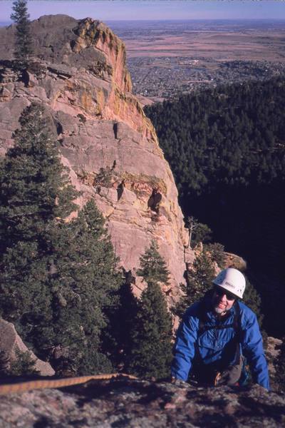 John Saccardi tops out after a surprisingly long amount of climbing on the 'South Ridge (5.2)' of the Overture. Photo by Tony Bubb, 2004. 