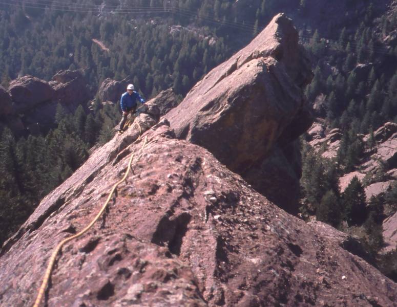 John Saccardi comes up the final arete section of 'Quadratic Equation' a good mellow slab high on Dinosaur Mountain, in the Flatirons. Photo by Tony Bubb, 2004.