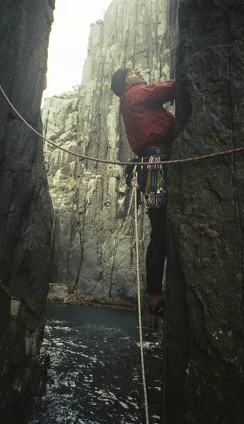 Beginning pitch 1 of the Free Route during my on sight ascent in Dec 2004.  Note the white tag line, and the fixed rap line which will later be used for the Tyrolean exit.