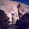 Tony Bubb puts his 'Heart and Sole' (10a) into sticking to the sunny and slick slab. Photo by Chris Parks, 12/02.