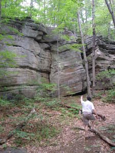 The Ben's Boot outcrop.  The Ben's Boot route ascends the crack in the shallow dihedral in the center of the face, and then climbs up an left through the overhangs above, to the top of the crag.  Bryan MacDonald, right.