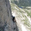 Clint following the traverse on pitch 8. The bolt is a still bit further out.