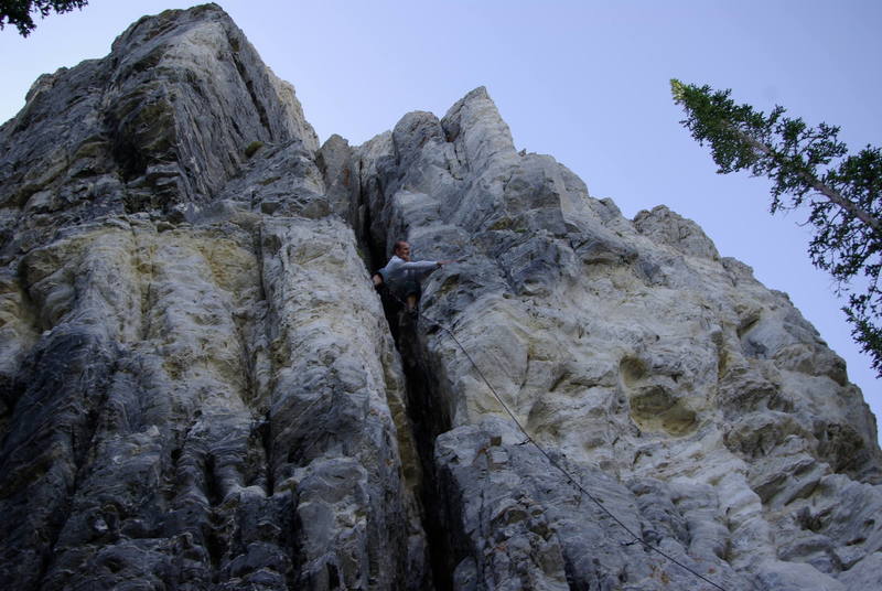 Adam after realizing that he forgot to clip a bolt. Downclimbing and reaching to clip it. 