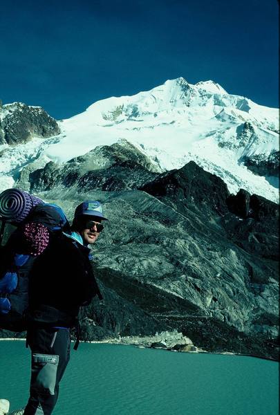 Entire normal route up Huayna Potosi in Bolivia is shown (6/93). After crossing dam and walking along the viaduct, which ends near the lighter colored rock, the route follows up the sharp lateral moraine. Our Camp 1 was just below the black slope in the middle of the picture. High Camp is at about  18,500 feet on the snow plateau above. The route then goes to the right and up through headwall to snow ridge on the right edge of the picture. Eventually a very sharp ridge leads to the left up to the approx. 20,000-foot high summit, which is the second and furthest peak in the photo. <br>
