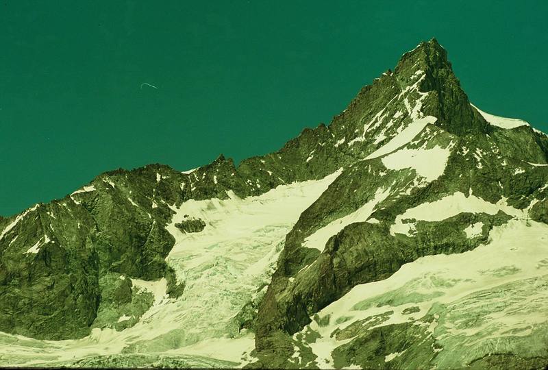 Hans Steykal and I climbed the Southwest Ridge of the Zinal-Rothorn starting at the notch about the mid point in the ridge (28 pitches, IV, 5.7). Crux is in chimney on north side above 13,000 feet. Approach from the Rothorn Hutte involved crossing 3 glaciers, 1 tricky Bergshrund and 4th Class rock. We descended the normal route (Southeast Ridge), which comes towards you in the picture. Our time hut to hut was 14 hrs. Epic descent hike (on rubbery legs after eating a meal) back to Zermatt occurred because we had to be in Chamonix the next day (7/90). Photo was taken from the summit of the Riffelhorn, which I soloed the day before and the same day Hans and I hiked up to the Rothorn Hutte. I had younger legs back then.