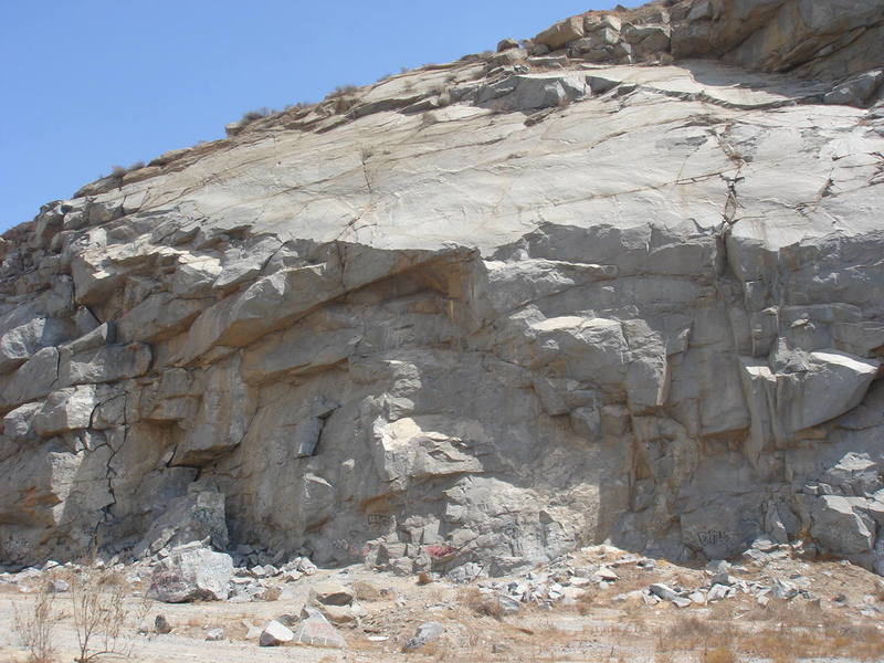 Slab City, on the far left end and just in front of the main wall of the Quarry.  [[105906823]] (5.10a) and [[105904286]] (5.10b) climb up to the large alcove in the center of the photo.