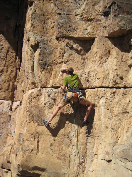 Finding some bigger holds above the sketchy rock in the big horizontal crack at about the climber's waist level in this photo.