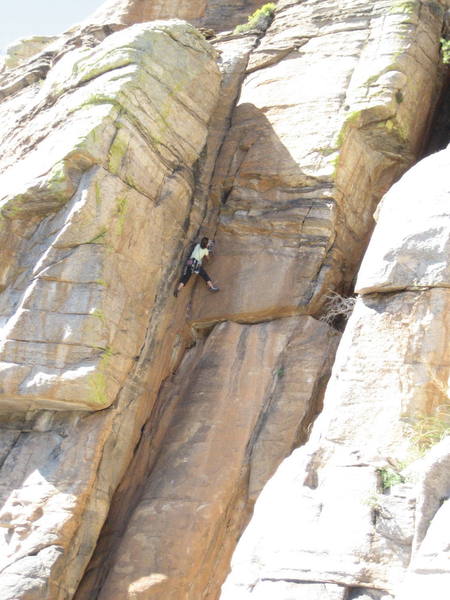 The route is ten feet right of Erica Bigio and climbs up through the horizontal banding that leads to the arete that leads to the seam at the left edge of the little roof.