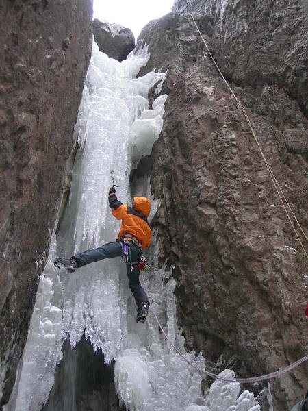 Ace Welton, delicately climbing up the P2 tube still open at the bottom. When rapping in to the river bottom, it may be considered prudent to leave a fixed line here, <em>just in case.</em>