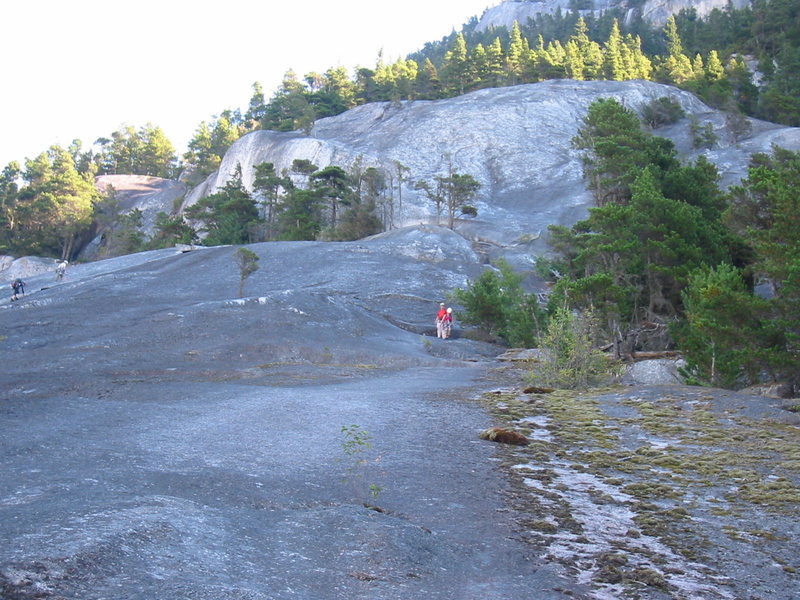 The two people in red with white helmets are debating following us down the Apron.  Over on the south side of the Apron, just before the trail enters the forest, you can head straight down, face-out.  Climbing shoes or sticky approach shoes recommended.  It's disconcerting, but works fine and cuts a fair bit of time off the descent.  I believe it has been mountain biked too...