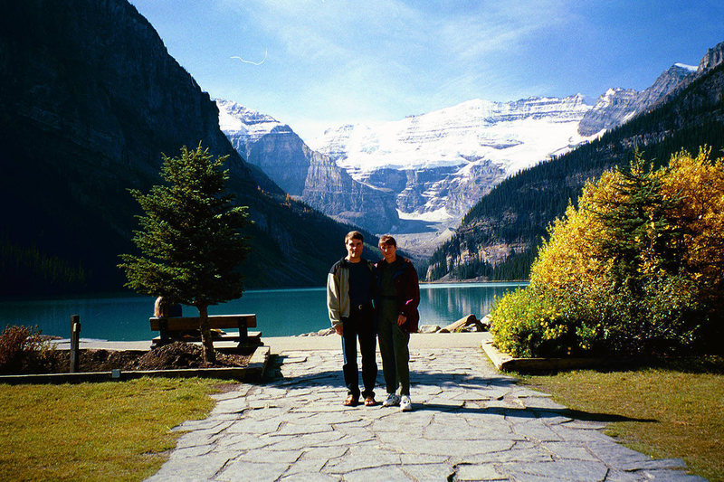 Joanne and I at Lake Louise from the front steps of the Chateau.  Mount Victoria dominates the background and the [[105893648]] crag is visible over Joanne's left shoulder.
