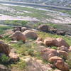 Turtle Dome area as seen from the lower up-road. Turtle Dome is the obvious cracked dome in the foreground. Further down, the other cracked formation is the "Baghouse" boulder, which isn't very inspiring due to poor quality rock with sharp holds. "Green" and "Gold" are located on the boulder at far right.