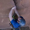 Adam Perks approaching the end of the opening hand/foot jamming moves on Flakes of Wrath (5.9+), Mim in the background with an attentive belay.