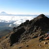 On the "saddle" where the first ridge meets steeper ground, Nancy Bell takes a water break and takes in the spectacular view. Cotopaxi is the snow-covered volcano in the background.