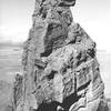 A view of the main summit from the south summit.  Note the climbers on the horn pitch in the lower-left part of the photograph.  Taken during the "Ship Rock 30th anniversary ascent" in 1969, just before the closure.