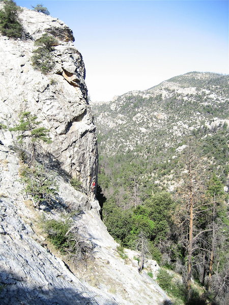 From the trail as it turns back to the south to reach the base of the cliff.  Stay as close to the base of the slabs as possible.  You want to walk right under Bobbin' For Hobbit's the route the climber (in red) is on. 