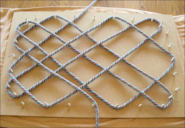 Start weaving the rope around the appropriate pegs, referring to template drawing to know when to go over or under.