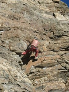 Starting the upper sequence. You can see the chalked up starting holds to the left of my elbow. All the holds here are big and positive, but the holds straight up at the bolts to my right are either small or sloped or both.<br>
Photo by Ken Parker.