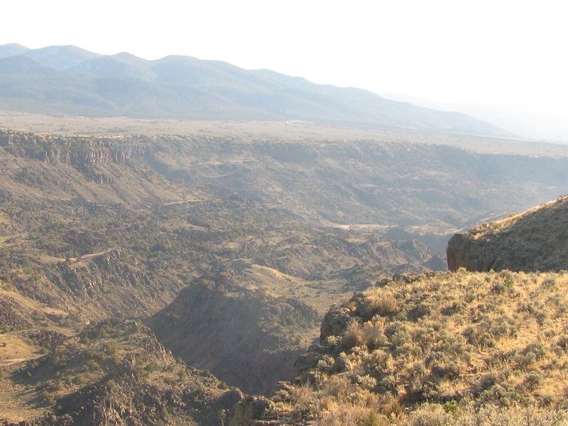 View from the rim at the parking spot above the crag. Upper tier climb anchors are right off the lip in the foreground.  The descent is a 100 ft further along this rim to the south (right in photo)