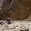 Bill Sherman pointing out the original P1 bolt traverse over to the belay.