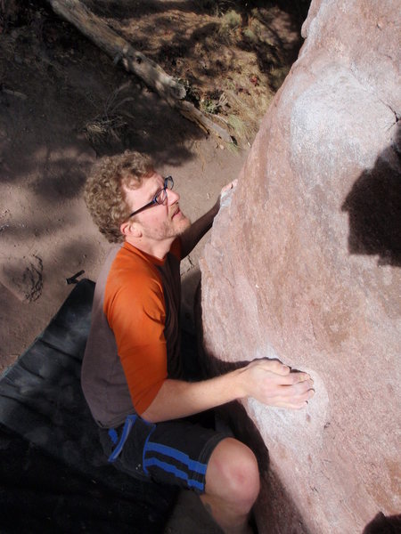 Jayson securing the right leg to move completely past the crux.