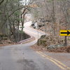 Looking back up to the road towards the entrance. The Cave Boulders are located down below the road/fence to the left about 100 meters past this sign.