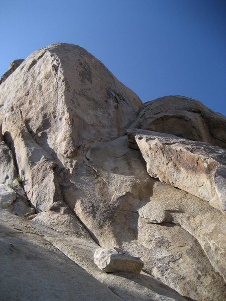 Where Have All The Cowboys Gone climbs the steep, shaded patina face in this photo.  The approach pitch (on Santa Cruz) starts to the right, out of this photo, in some thin cracks on a detached slab.  The belay for Cowboys is where the detached slab rock touches the steep face.