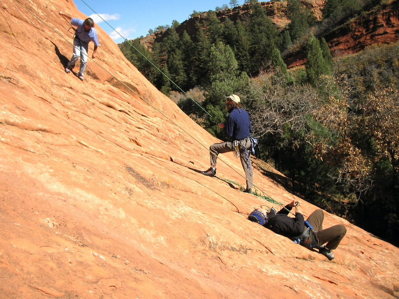 Grossman demonstrates his famous upside down hip belay while Becker shows old school stupidity by lowering face first in a swami belt! 